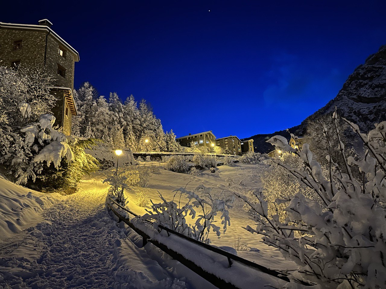 Photo of a snow-covered road at dusk in Canillo, Andorra.